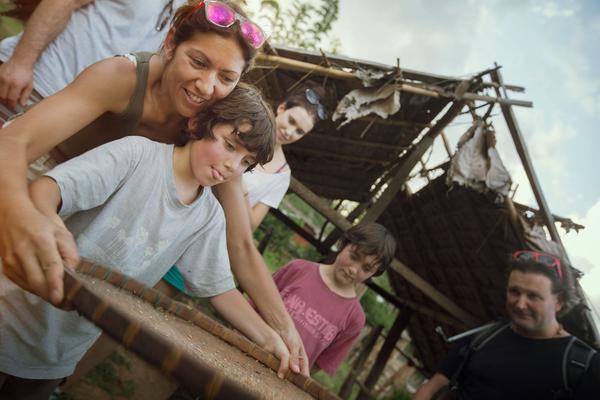 family tour gazing sorting grain with a wooden pan