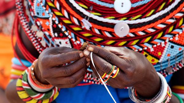 the hands of a local Kenyan woman wearing colourful traditional dress