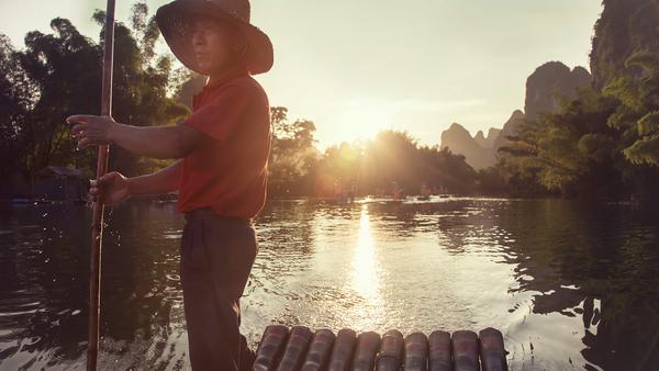 Man on bamboo raft in Yangshuo China