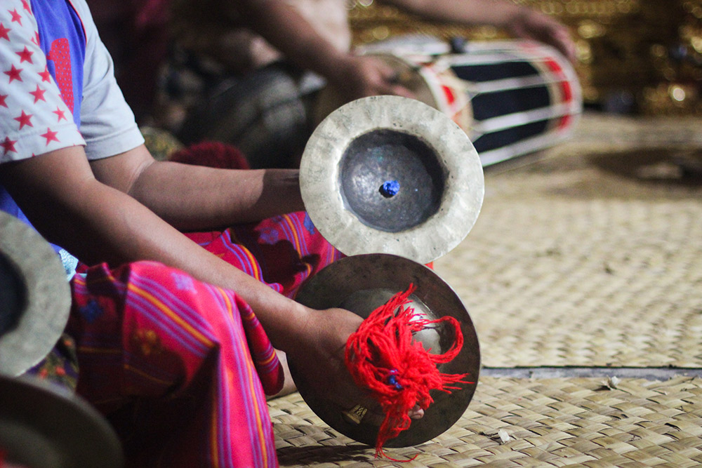 A member of the orchestra plays a pair of ceng-ceng cymbals.